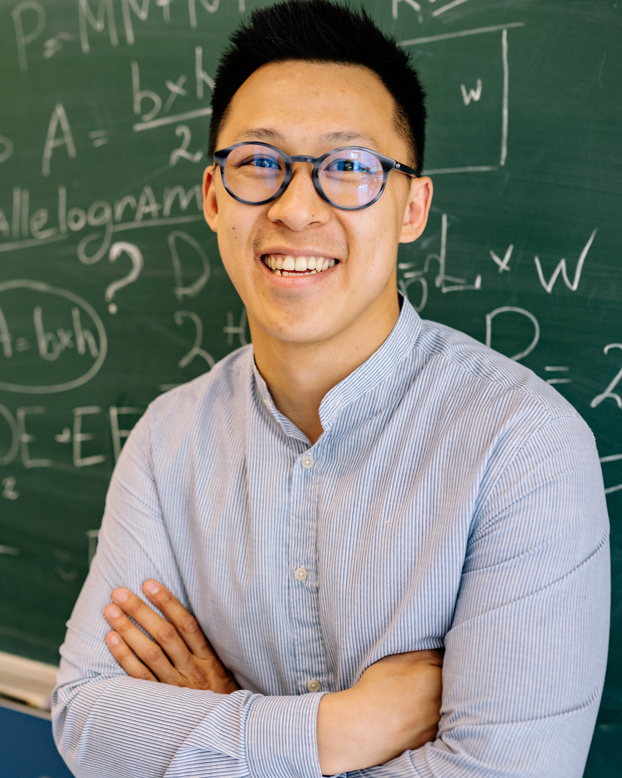 Male teacher in front of chalk board